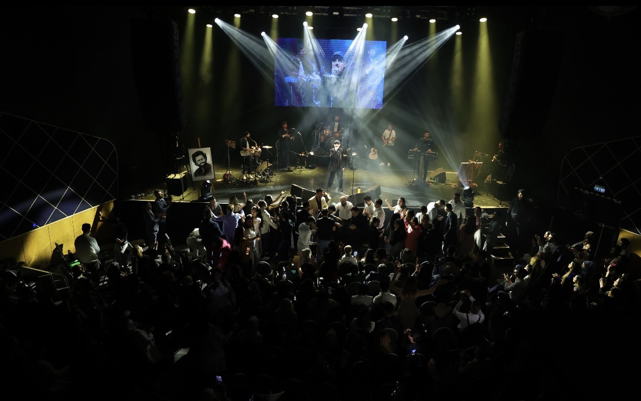 Band performing on stage under spotlights